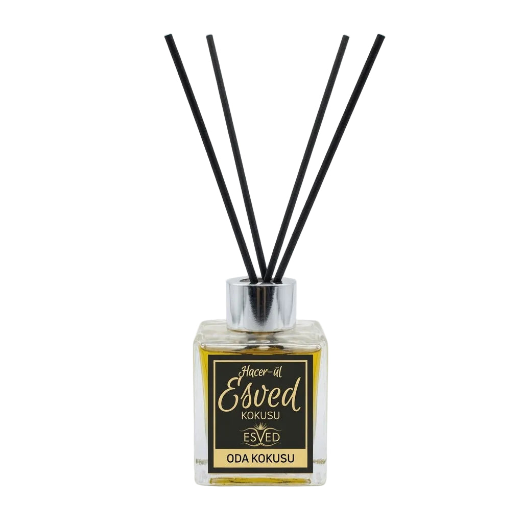 A reed diffuser bottle with a square clear glass container filled with amber liquid, a black and gold label reading 'Esved Kokusu' and 'Oda Kokusu', and four black reed sticks in a silver cap, photographed on a light gray background.