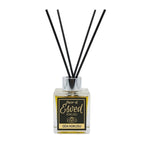 A reed diffuser bottle with a square clear glass container filled with amber liquid, a black and gold label reading 'Esved Kokusu' and 'Oda Kokusu', and four black reed sticks in a silver cap, photographed on a light gray background.